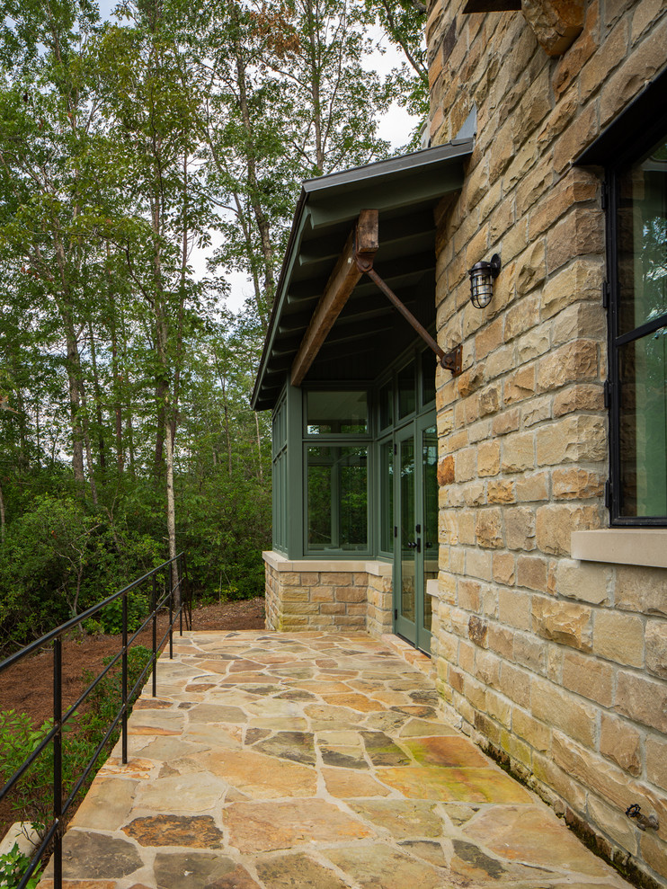 Immagine di un grande patio o portico country dietro casa con pavimentazioni in pietra naturale e nessuna copertura