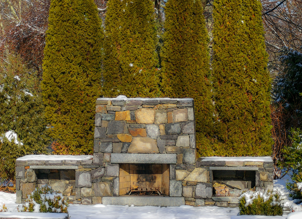 Immagine di un patio o portico chic di medie dimensioni e dietro casa con un focolare e pavimentazioni in pietra naturale