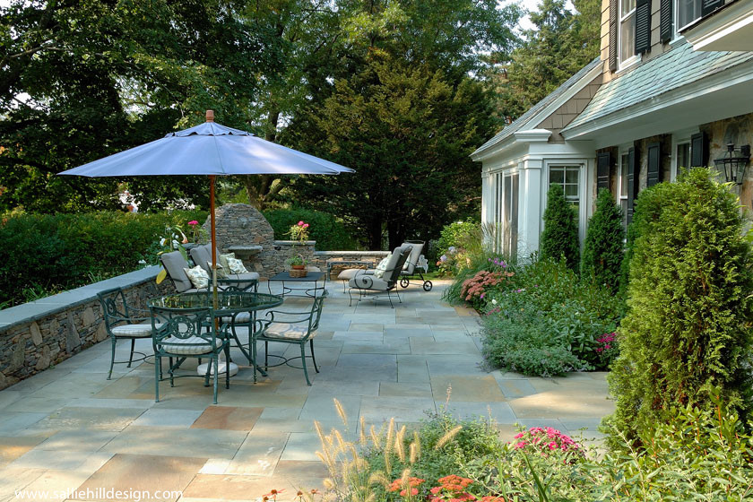 Immagine di un grande patio o portico classico dietro casa con fontane e pavimentazioni in pietra naturale