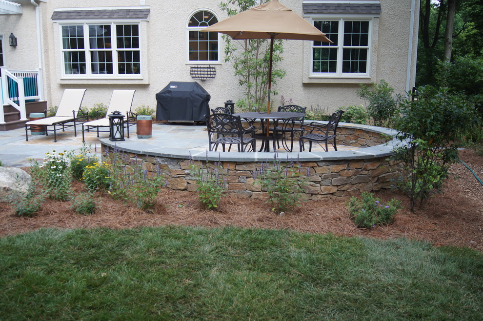 Imagen de patio clásico grande en patio trasero con suelo de baldosas y pérgola