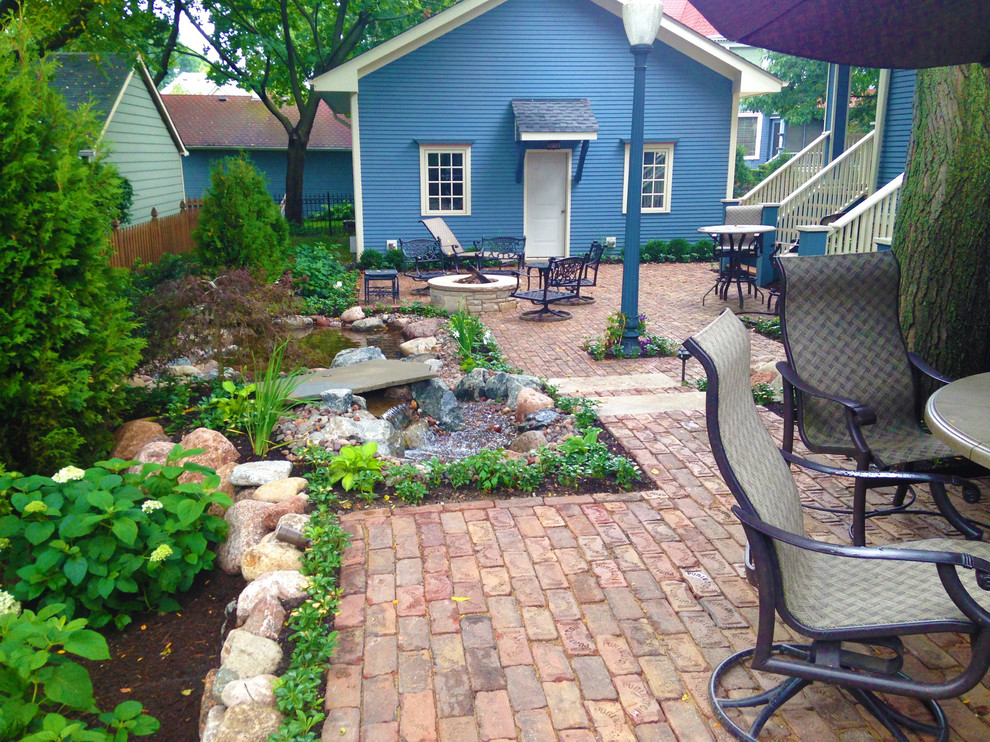 Design ideas for a medium sized traditional back patio in Chicago with brick paving.