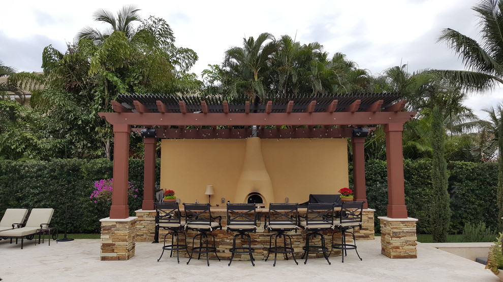 Inspiration for a mid-sized southwestern backyard tile patio kitchen remodel in Miami with a pergola