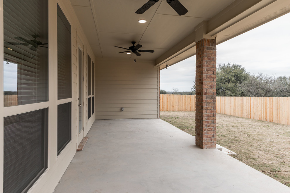 На фото: двор среднего размера на заднем дворе в классическом стиле с покрытием из бетонных плит и навесом с