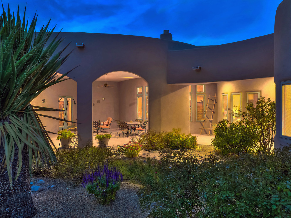 Großer, Überdachter Mediterraner Patio hinter dem Haus mit Kamin und Stempelbeton in Albuquerque