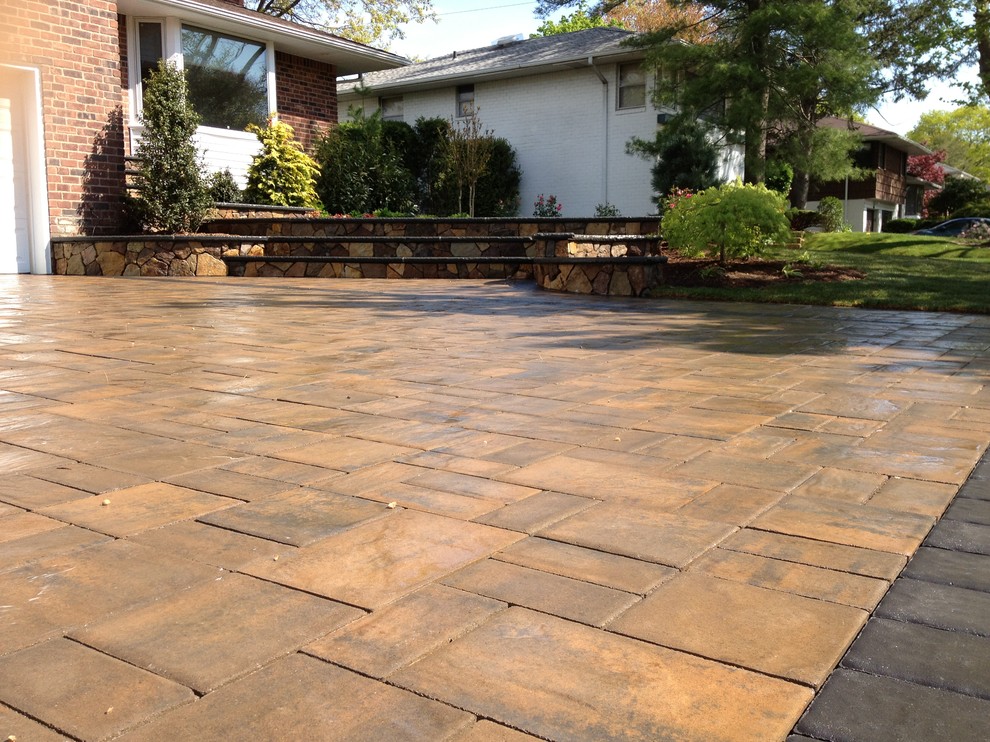 Example of a mid-sized classic front yard stamped concrete patio design in New York with no cover