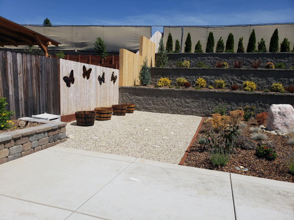 Immagine di un grande patio o portico tradizionale dietro casa con lastre di cemento