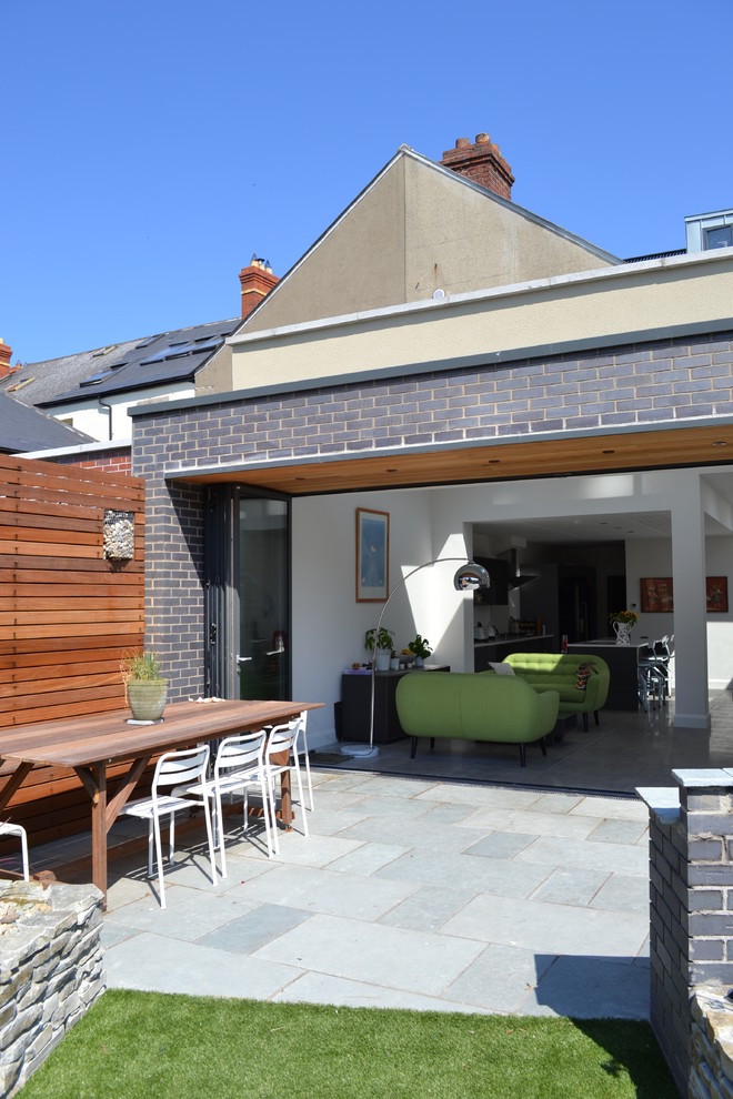Modelo de patio minimalista de tamaño medio en patio trasero y anexo de casas con jardín vertical y adoquines de piedra natural