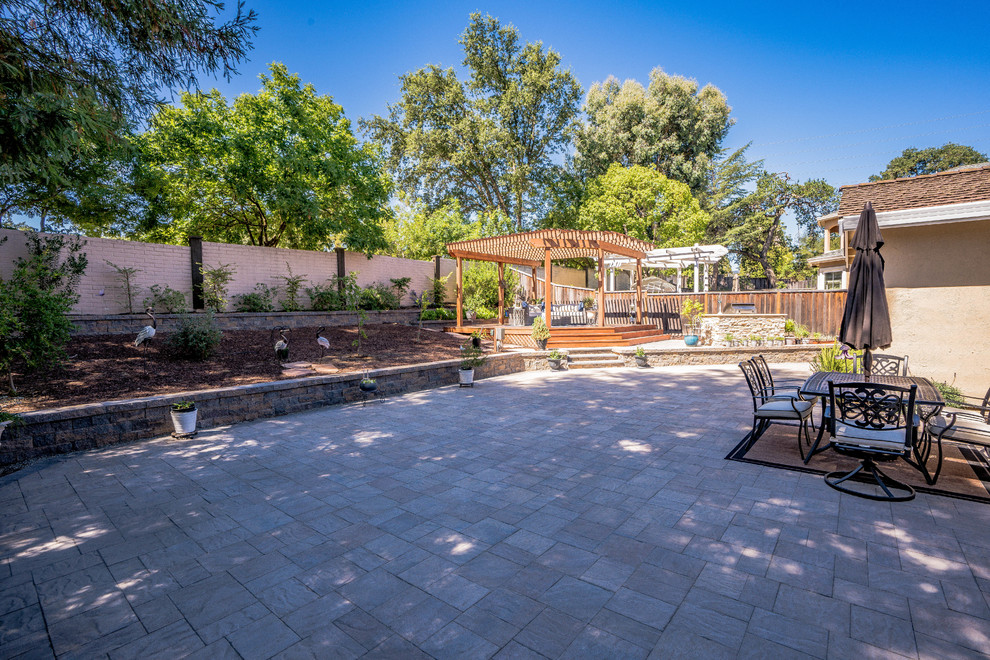 Immagine di un ampio patio o portico stile americano dietro casa con pavimentazioni in pietra naturale e un parasole