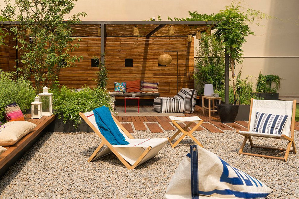 Immagine di un grande patio o portico minimal dietro casa con un giardino in vaso, ghiaia e una pergola