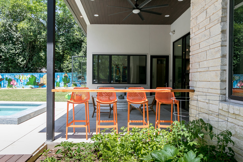 Photo of a contemporary back patio in Austin with concrete slabs and a roof extension.