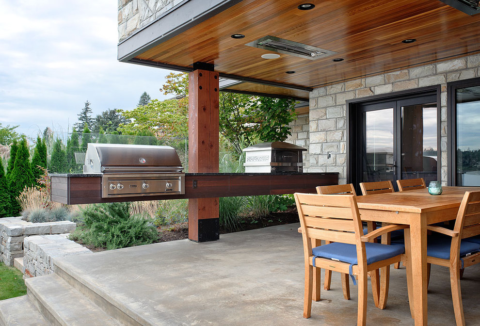 Contemporary patio in Seattle with a roof extension.
