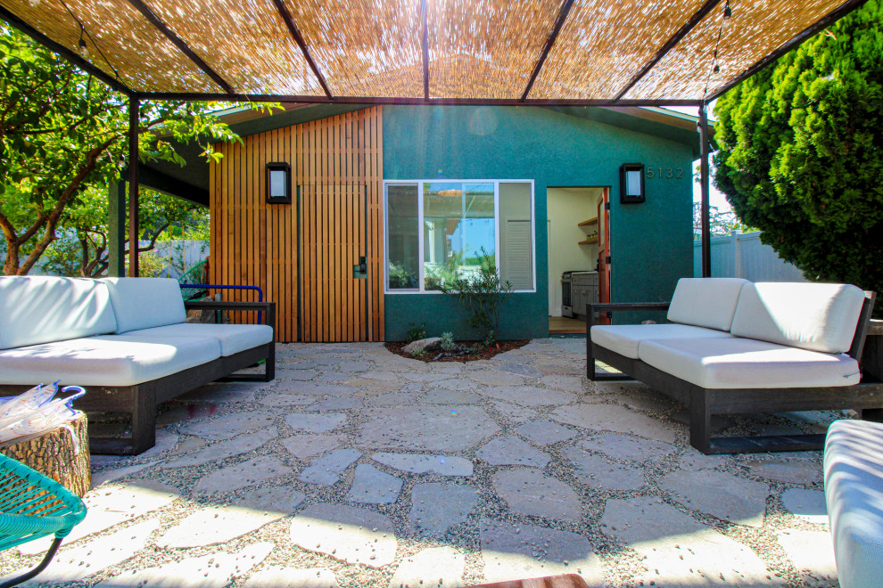 Foto de patio tradicional de tamaño medio en patio delantero con adoquines de piedra natural, pérgola y jardín de macetas