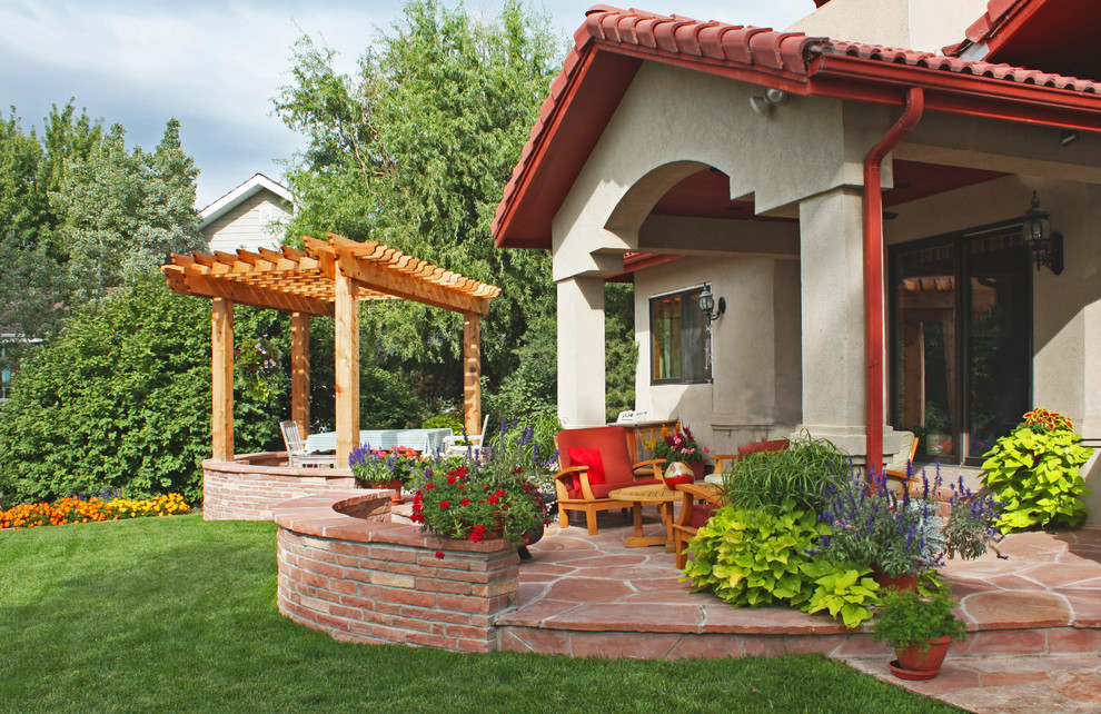 Foto di un patio o portico american style di medie dimensioni e dietro casa con una pergola, un giardino in vaso e pavimentazioni in pietra naturale