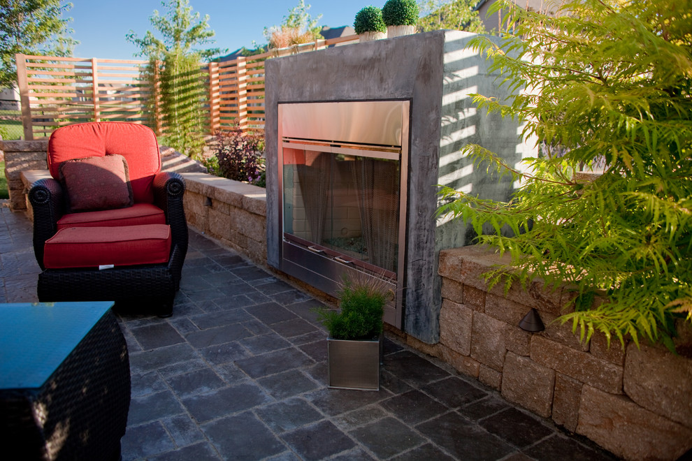 Patio - large contemporary backyard stone patio idea in Other with a fire pit and no cover