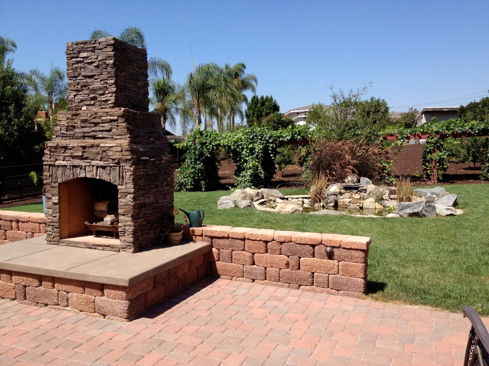 Große Klassische Pergola hinter dem Haus mit Feuerstelle und Pflastersteinen in San Diego