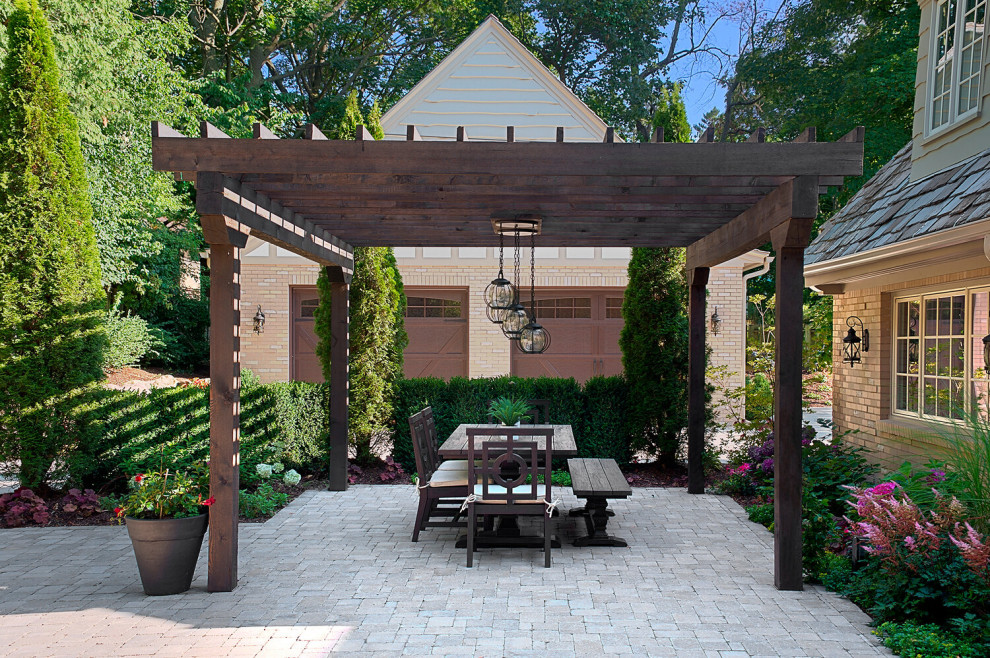 Inspiration for a huge timeless backyard brick patio remodel in Grand Rapids with a pergola