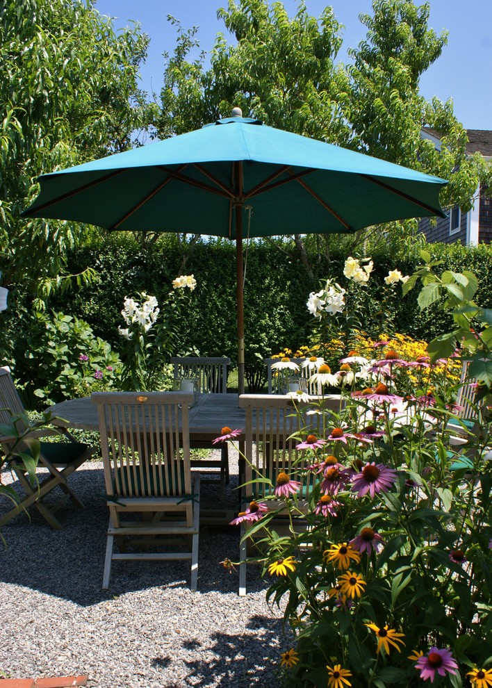 Esempio di un patio o portico classico di medie dimensioni e nel cortile laterale con un giardino in vaso, ghiaia e nessuna copertura