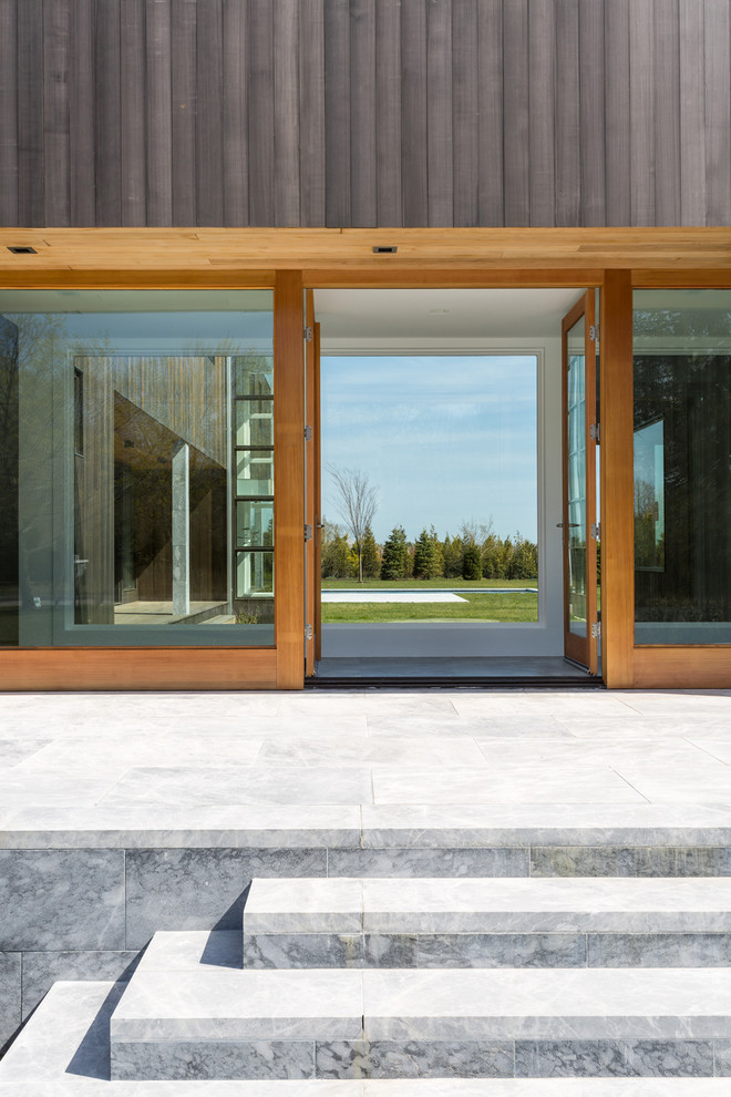 Inspiration pour une terrasse arrière design de taille moyenne avec des pavés en pierre naturelle et aucune couverture.