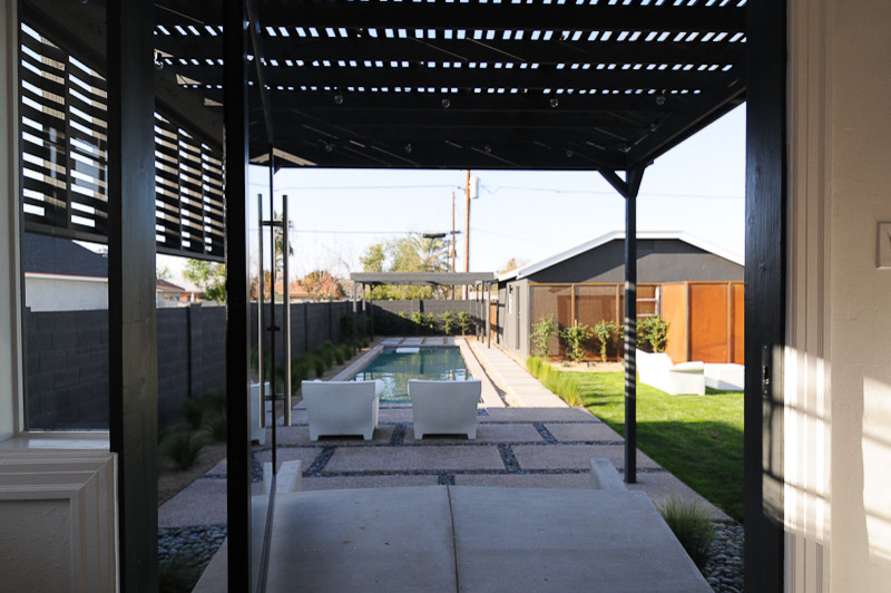 Diseño de patio moderno de tamaño medio en patio trasero con losas de hormigón y cenador