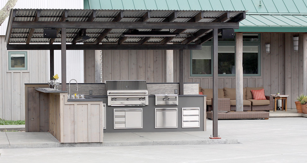 This is an example of a medium sized contemporary back patio in San Francisco with an outdoor kitchen, concrete slabs and a pergola.