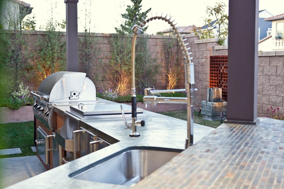 Cette photo montre une petite terrasse arrière éclectique avec une cuisine d'été, du carrelage et une pergola.