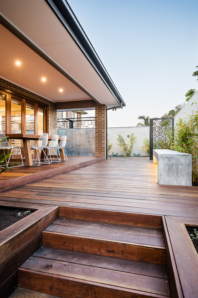 Inspiration pour une terrasse arrière minimaliste avec une cuisine d'été et une extension de toiture.