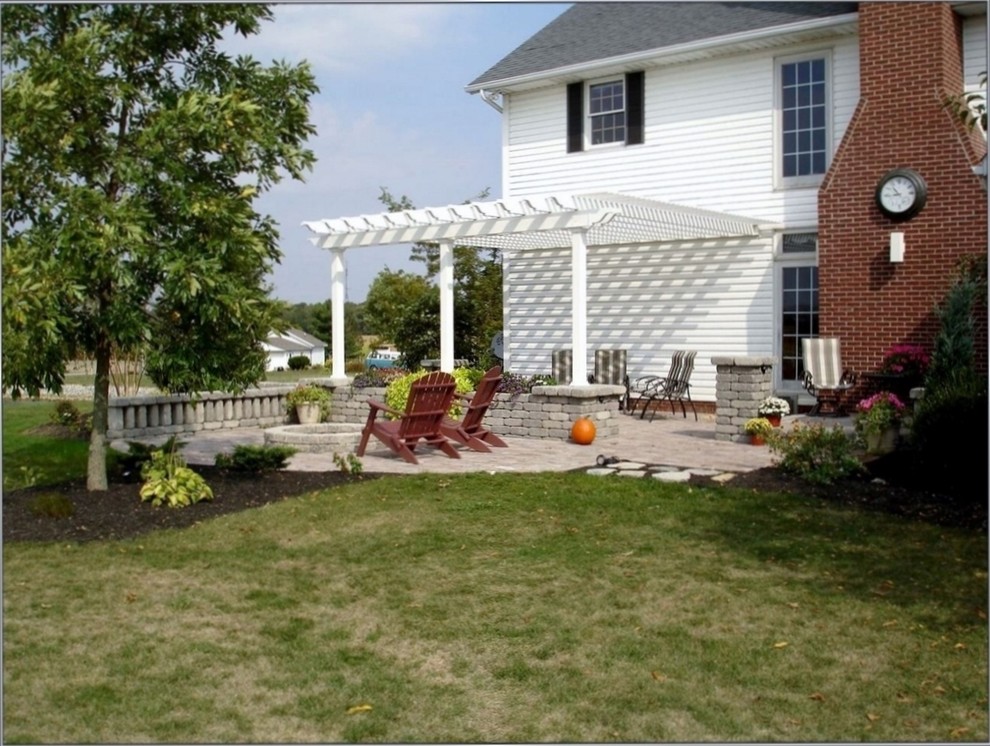Diseño de patio clásico de tamaño medio en patio trasero con brasero, adoquines de hormigón y pérgola
