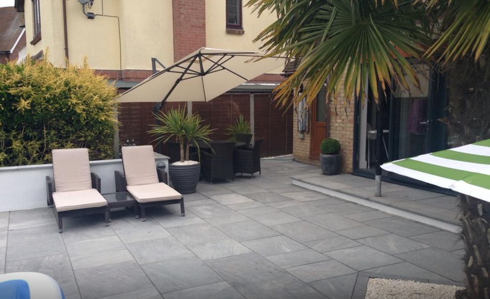 Patio - mid-sized contemporary backyard stone patio idea in Essex