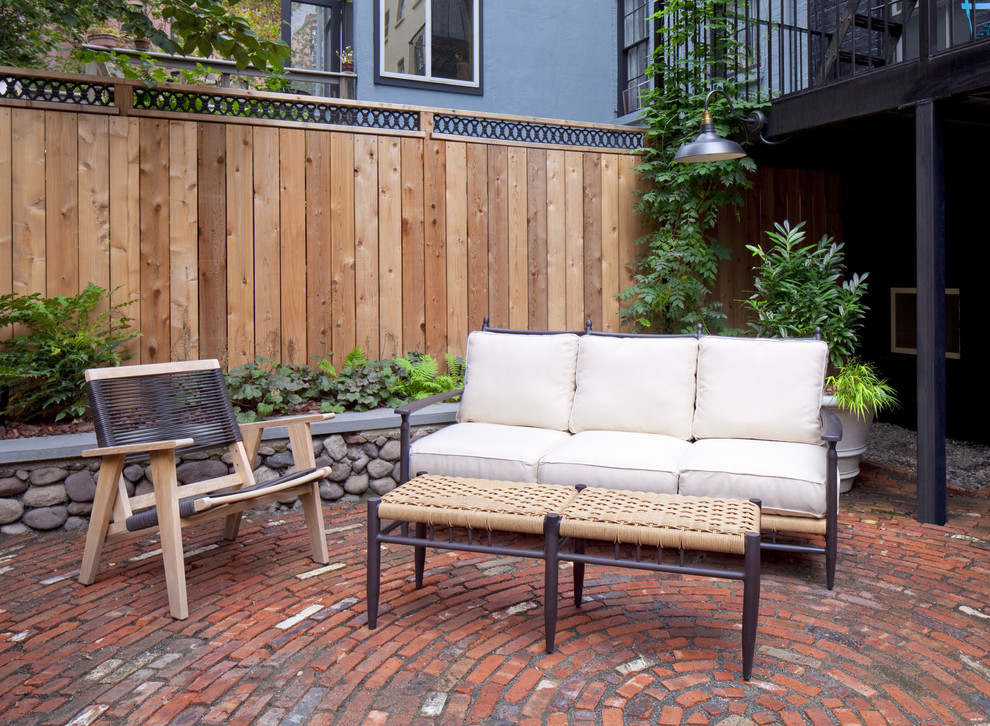 Idee per un piccolo patio o portico eclettico dietro casa con pavimentazioni in mattoni