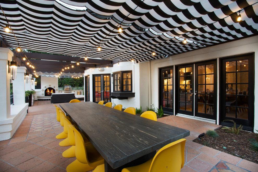 Стильный дизайн: двор среднего размера на боковом дворе в стиле фьюжн с летней кухней, козырьком и покрытием из плитки - последний тренд