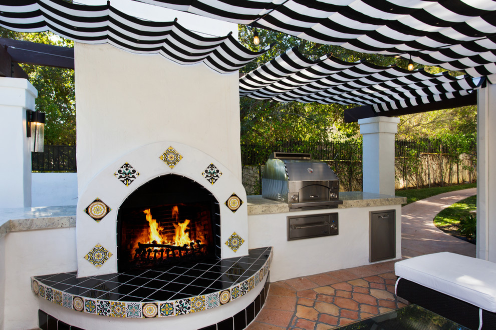 Großer, Gefliester Klassischer Patio hinter dem Haus mit Outdoor-Küche und Markisen in Los Angeles