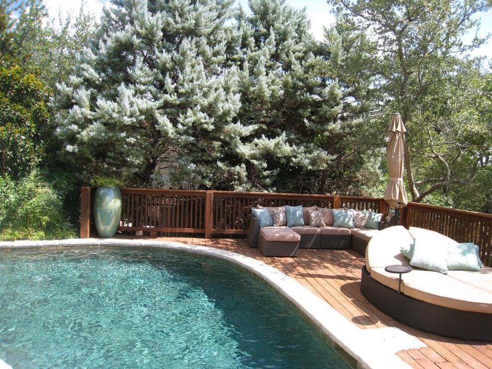 Diseño de piscina ecléctica de tamaño medio en patio trasero con entablado