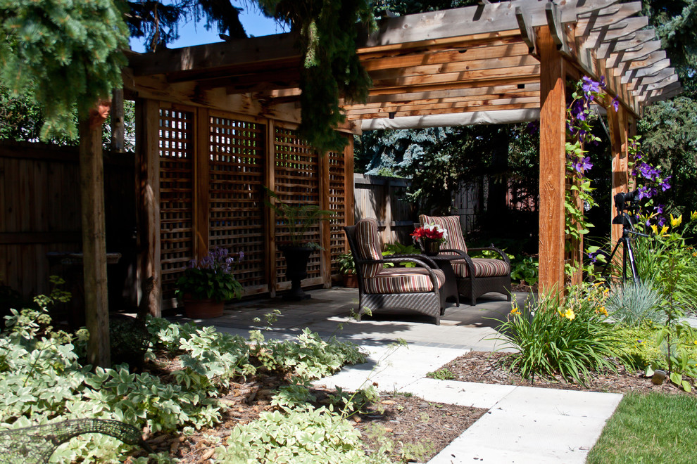 Patio - large eclectic backyard brick patio idea in Edmonton with a pergola
