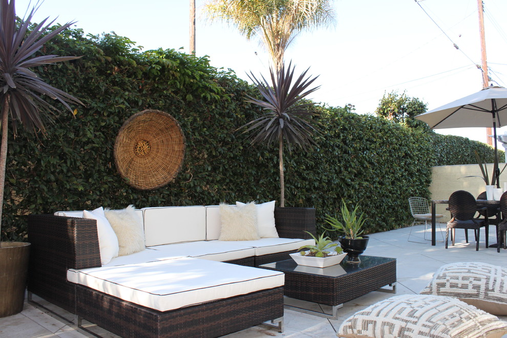 Bohemian back patio in Orange County with no cover and concrete slabs.