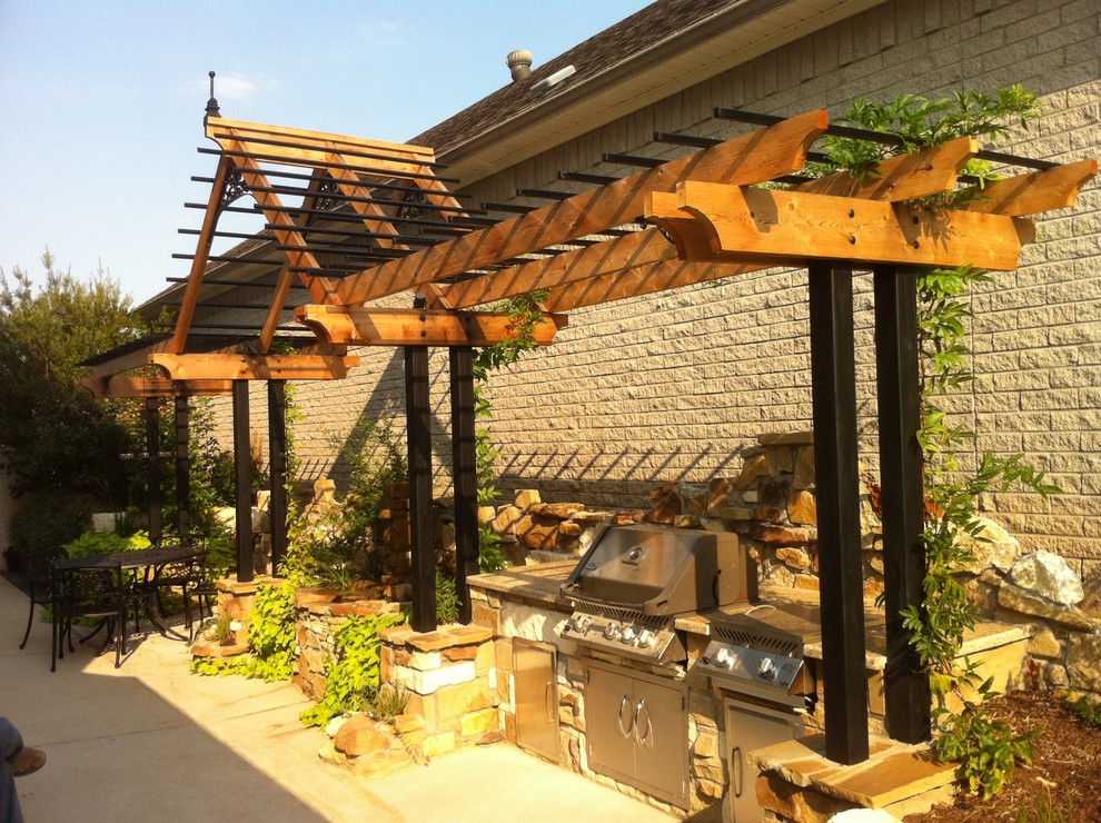 На фото: пергола во дворе частного дома на внутреннем дворе в стиле фьюжн с летней кухней и покрытием из бетонных плит