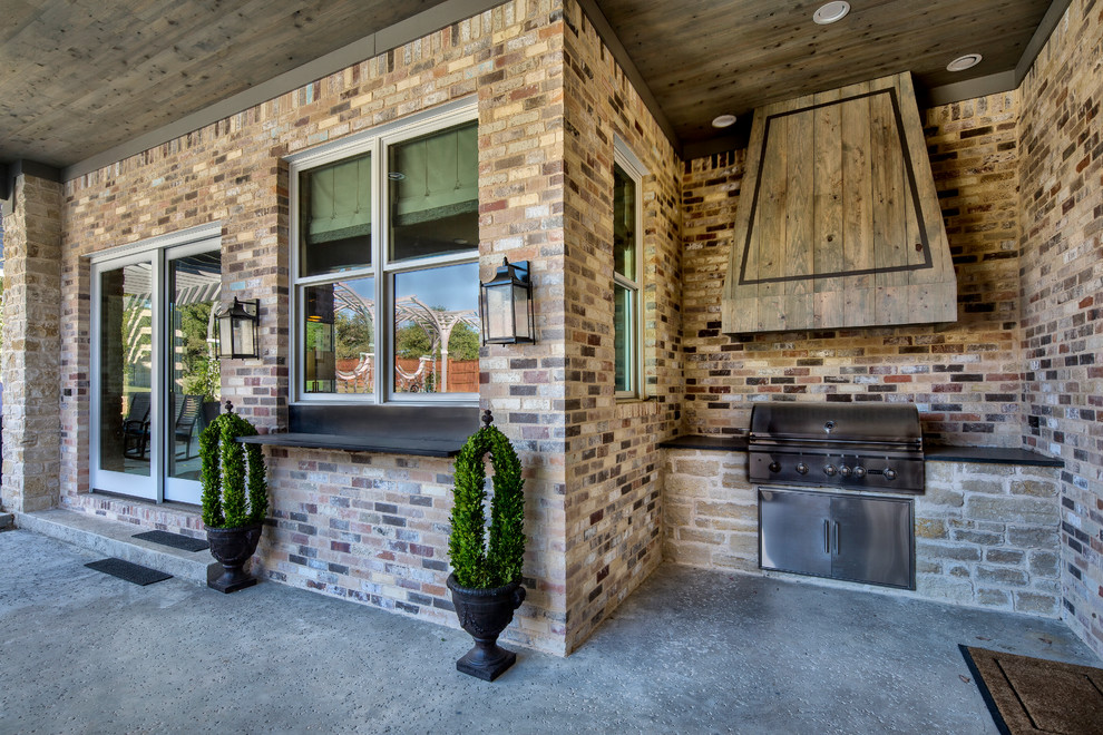Cette photo montre une grande terrasse arrière éclectique avec une cuisine d'été, du béton estampé et une extension de toiture.