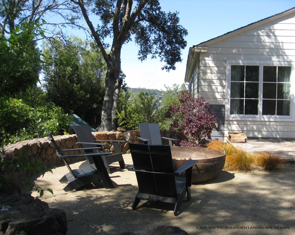 Esempio di un patio o portico chic di medie dimensioni con un focolare e graniglia di granito
