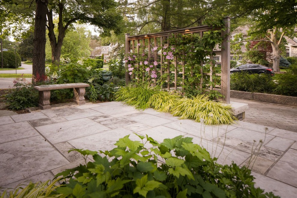 Exemple d'une terrasse arrière tendance de taille moyenne avec une cuisine d'été, des pavés en pierre naturelle et une pergola.