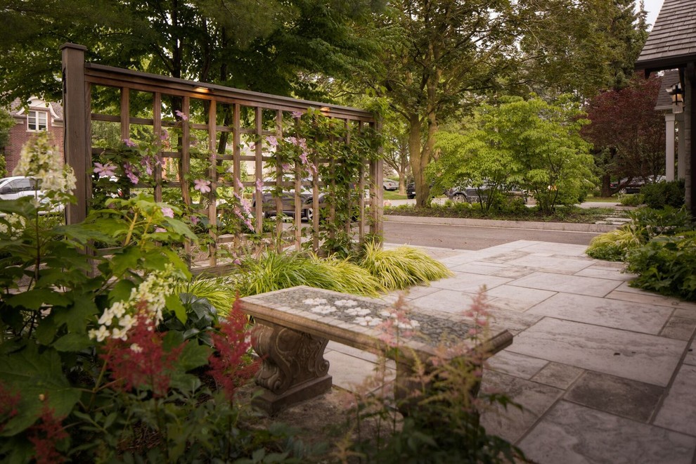 Idee per un patio o portico minimal di medie dimensioni e dietro casa con pavimentazioni in pietra naturale e una pergola