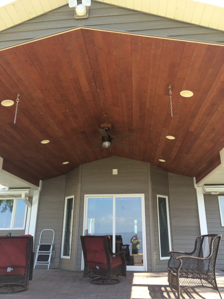 Cette image montre une terrasse arrière traditionnelle de taille moyenne avec une cuisine d'été, du béton estampé et une extension de toiture.