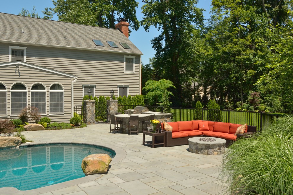 Immagine di un grande patio o portico classico dietro casa con un focolare, pavimentazioni in cemento e nessuna copertura