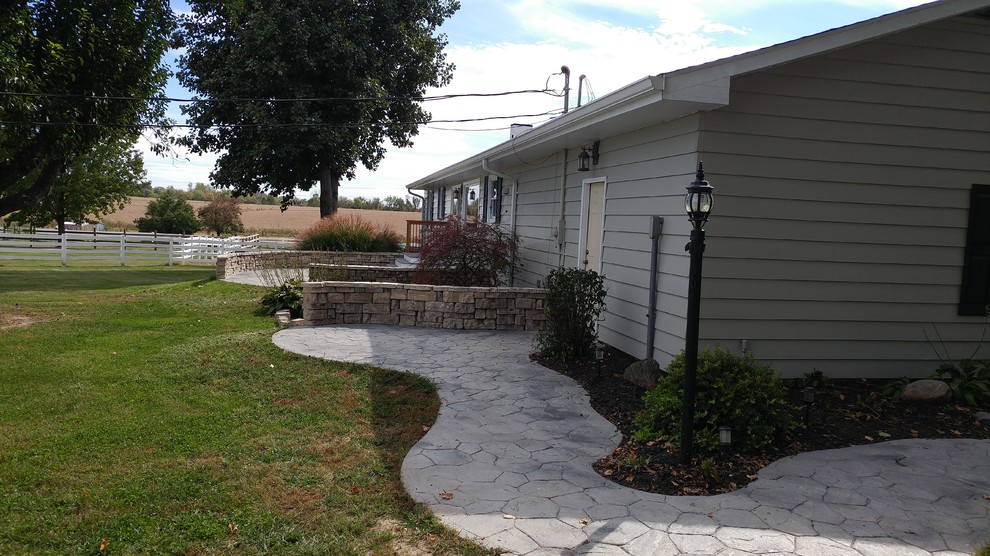 Idee per un ampio patio o portico country dietro casa con cemento stampato