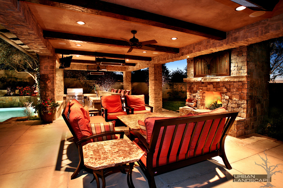 Patio kitchen - large mediterranean backyard stone patio kitchen idea in Orange County with a gazebo