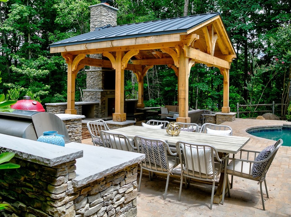 Cette image montre une grande terrasse arrière craftsman avec une cuisine d'été, des pavés en béton et un gazebo ou pavillon.