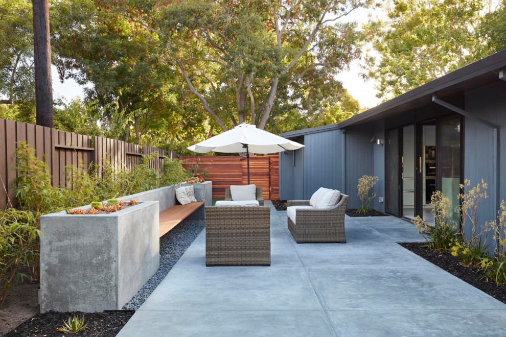 Imagen de patio retro de tamaño medio sin cubierta en patio trasero con adoquines de hormigón