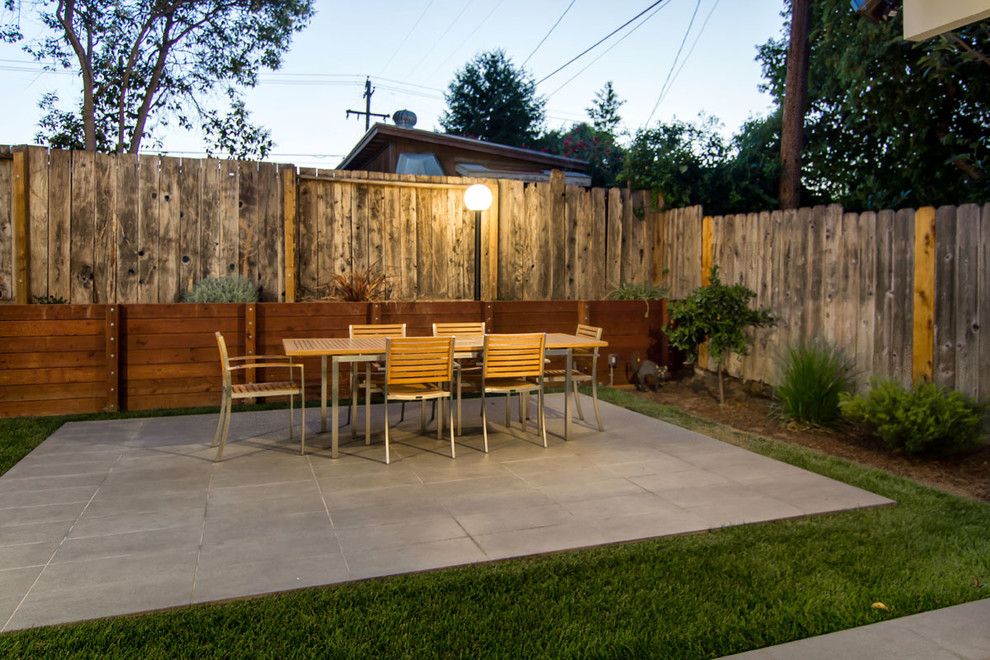 Idee per un patio o portico minimalista di medie dimensioni e dietro casa con piastrelle e un tetto a sbalzo