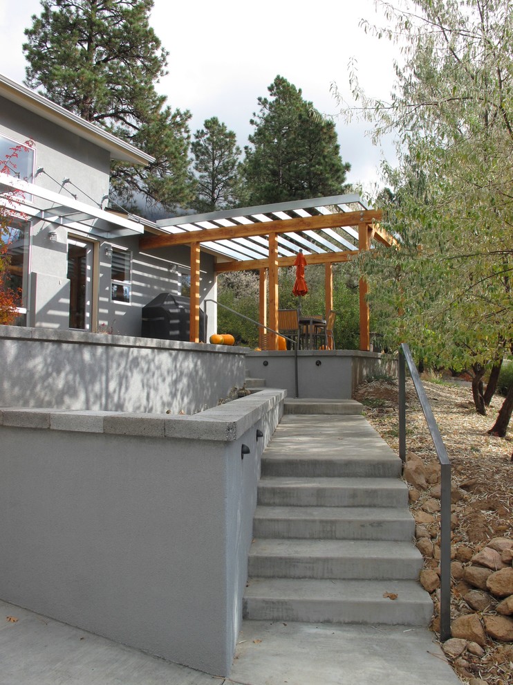 Imagen de patio contemporáneo en patio delantero con adoquines de hormigón y pérgola
