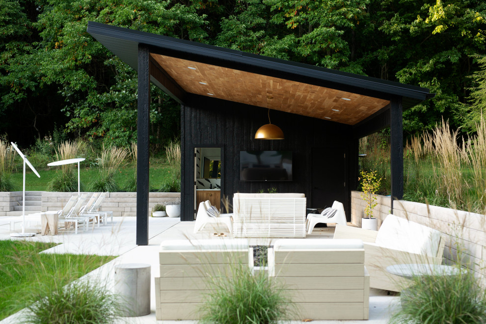 Пример оригинального дизайна: двор в современном стиле с покрытием из бетонных плит и навесом