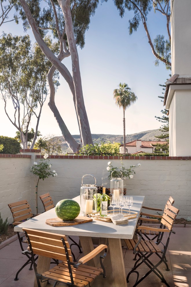 Inspiration for a mid-sized timeless backyard concrete paver patio remodel in Orange County with no cover