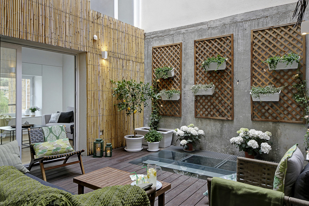 Ispirazione per un patio o portico eclettico in cortile con un giardino in vaso e pedane